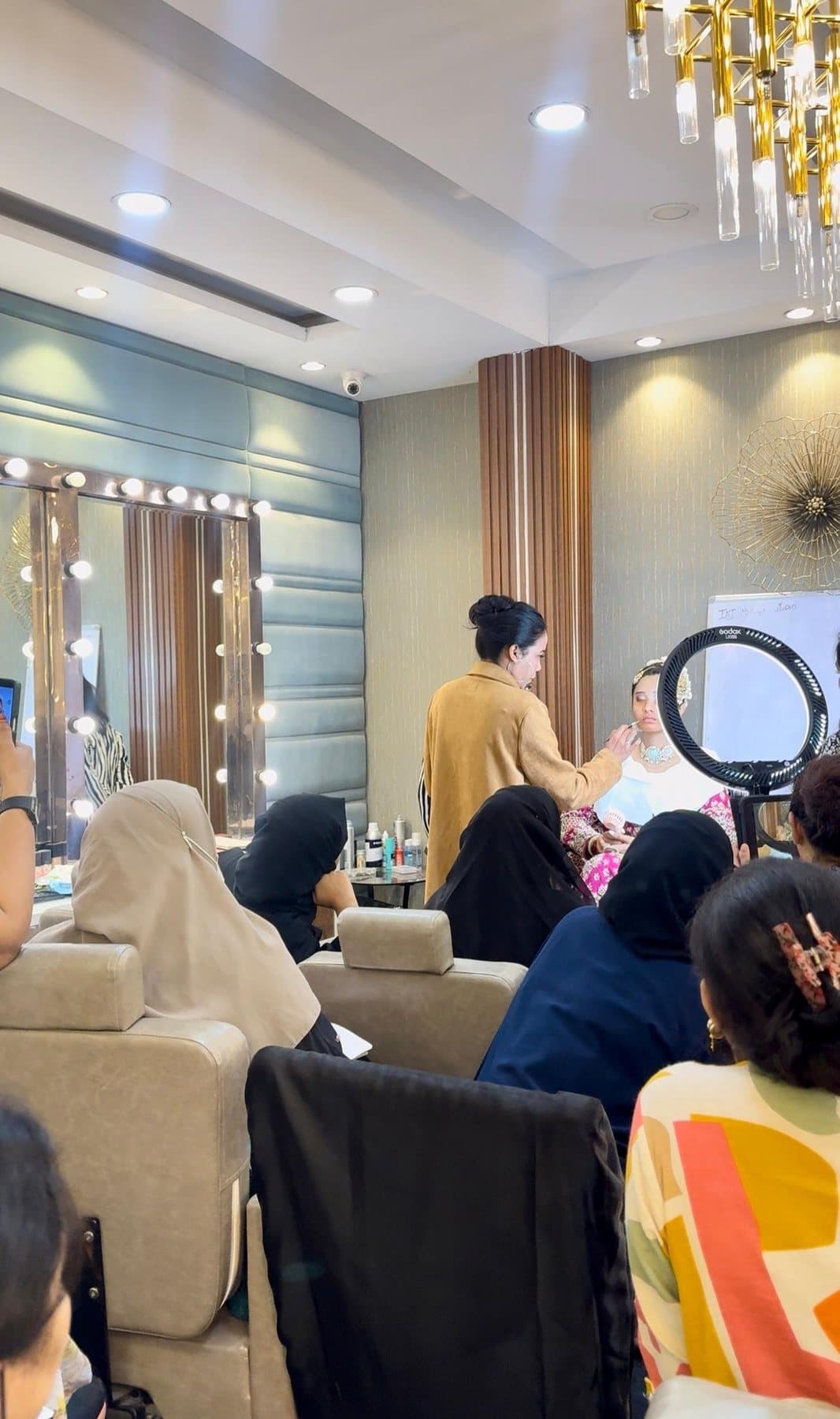 Makeup class in progress at the INJ studio, with students watching a live demonstration