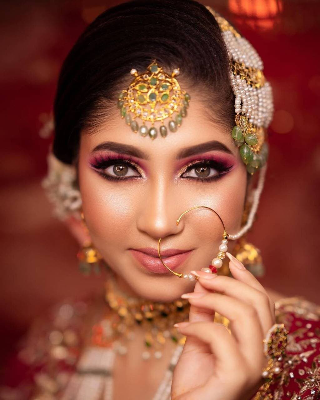 Close-up bridal portrait with a gold maang tikka, kundan jewellery and soft rose-toned eye makeup