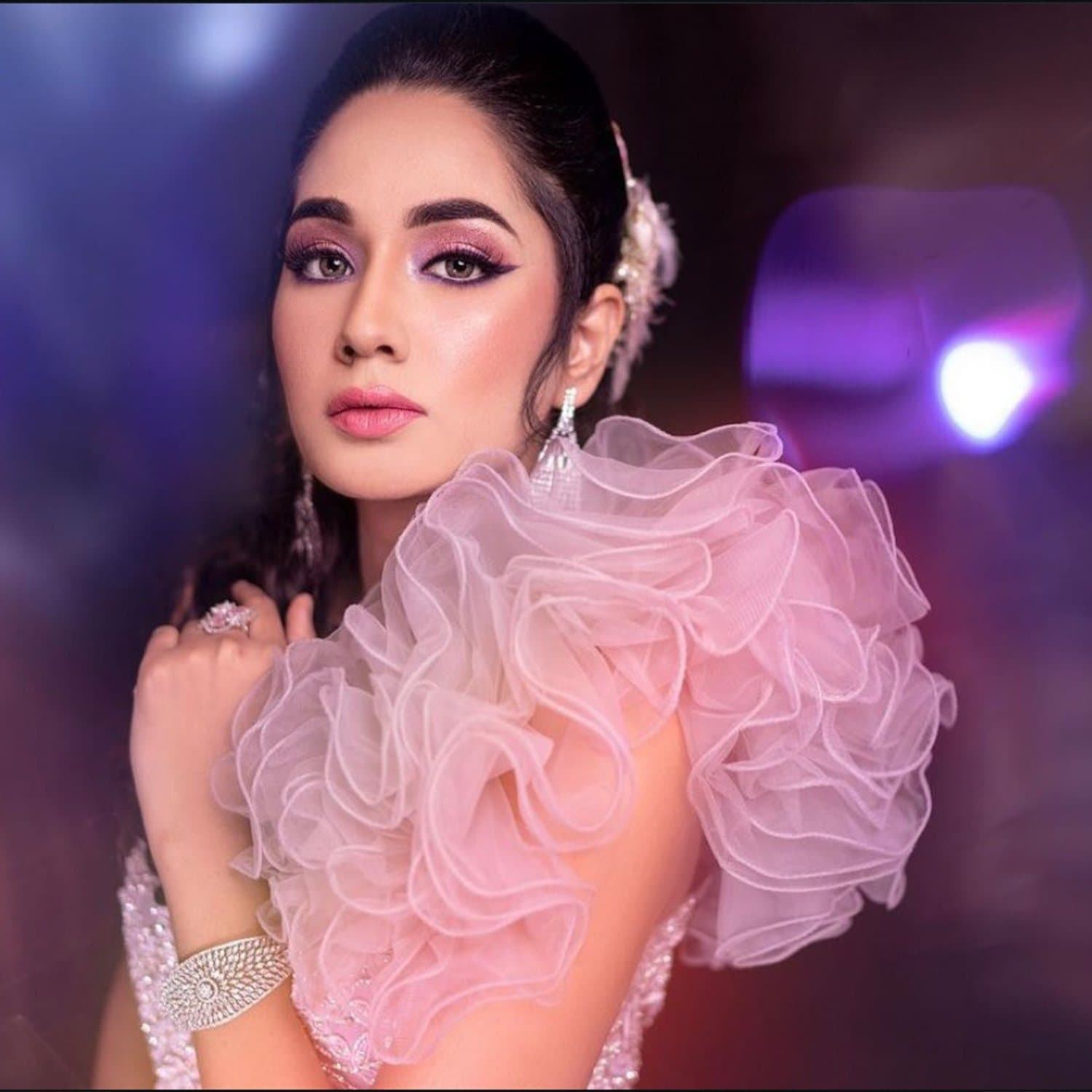 Editorial portrait with lilac eye makeup and a voluminous pink organza ruffle