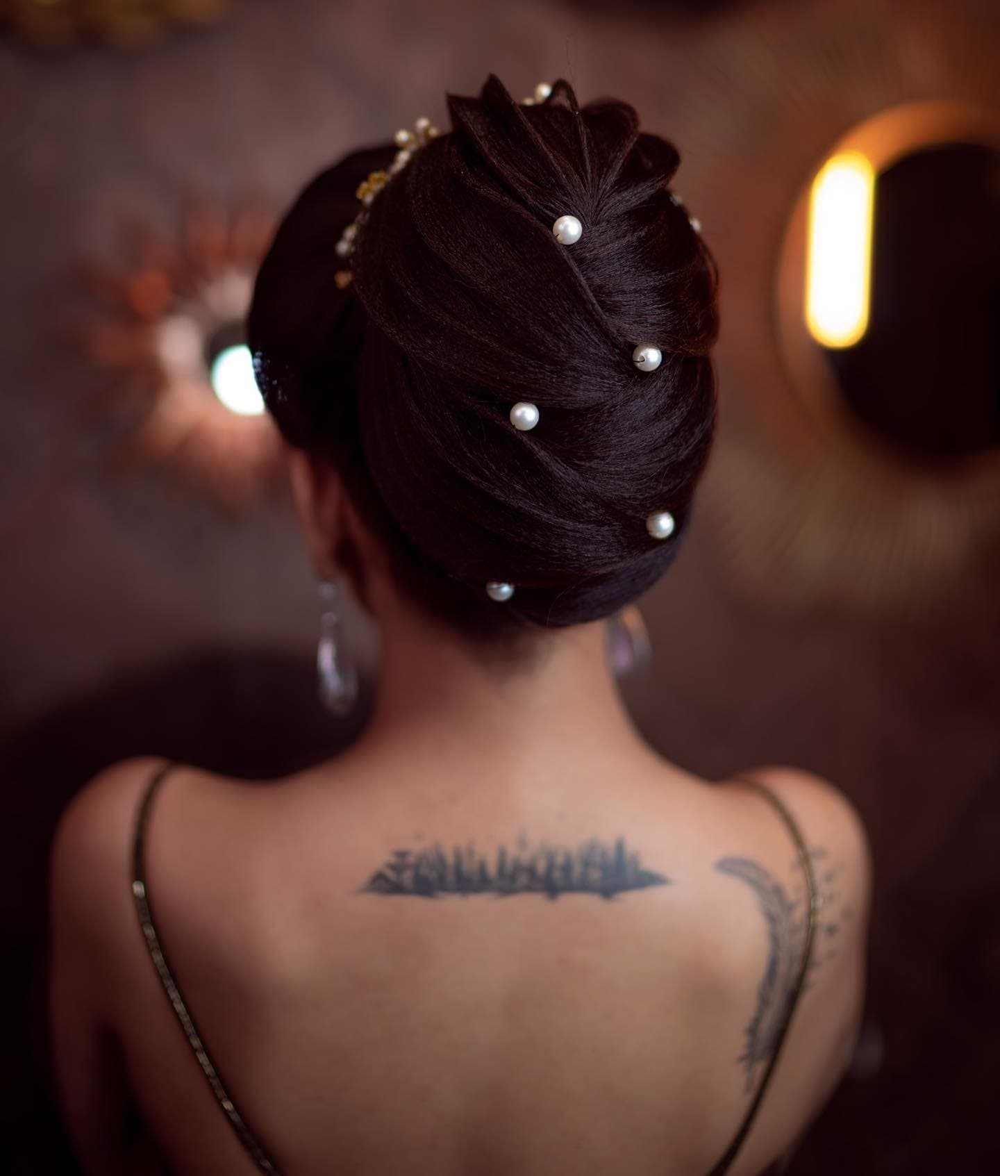 Back view of a sculpted bridal bun finished with pearl hair pins